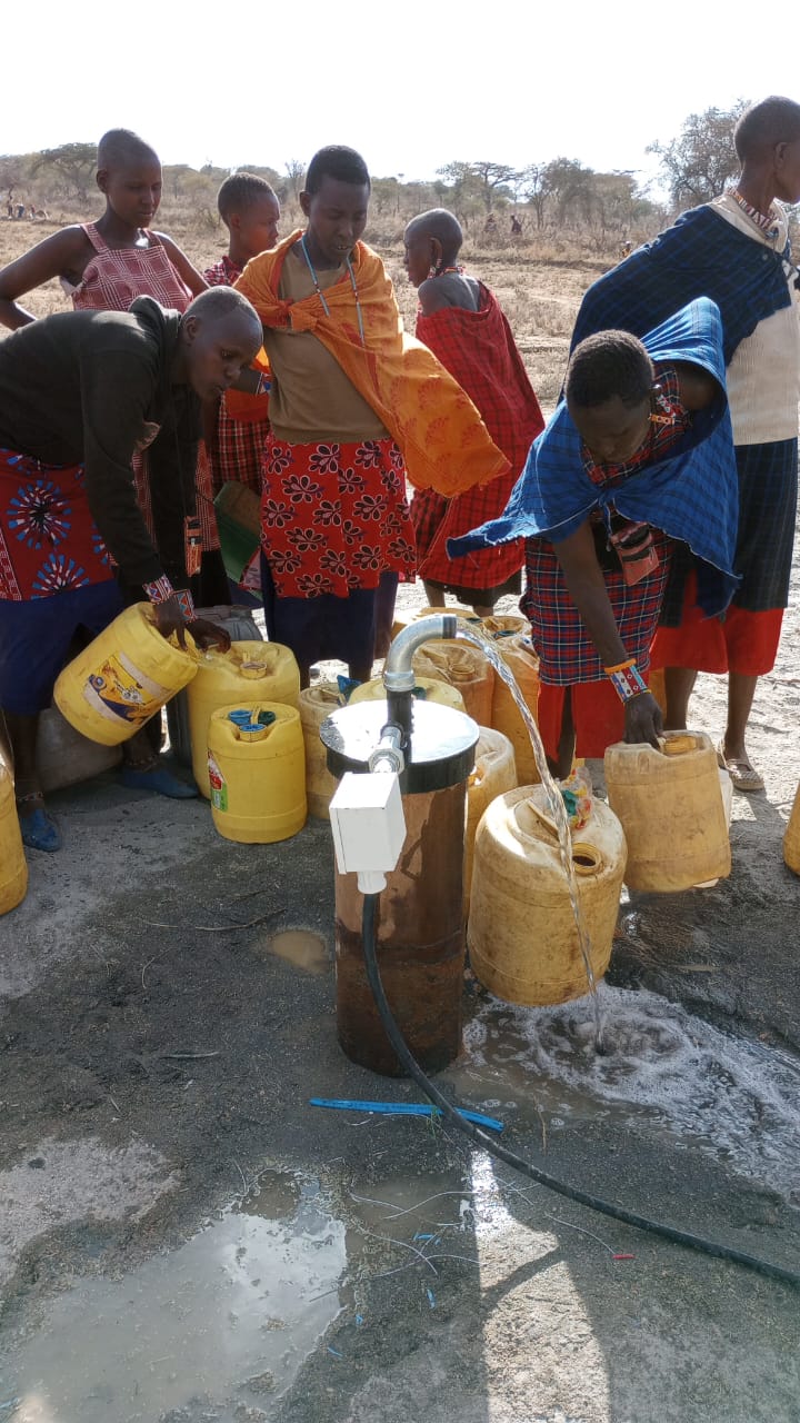 Potable borehole water flowing from wellhead spigot for community distribution