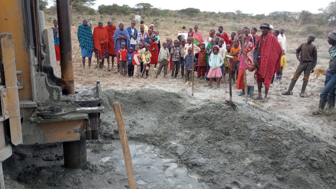 Local pastoralist community gathered to observe active borehole drilling operations