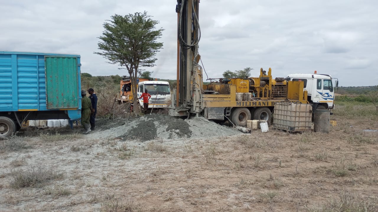 Milimani Drilling heavy DTH rig and support trucks operating on site