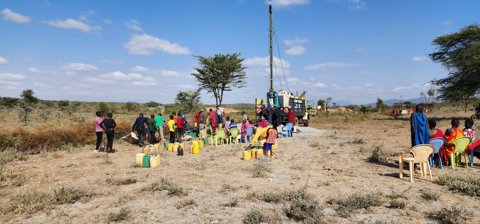 Milimani mobile service rig conducting borehole pump testing and pump installation with local community gathered
